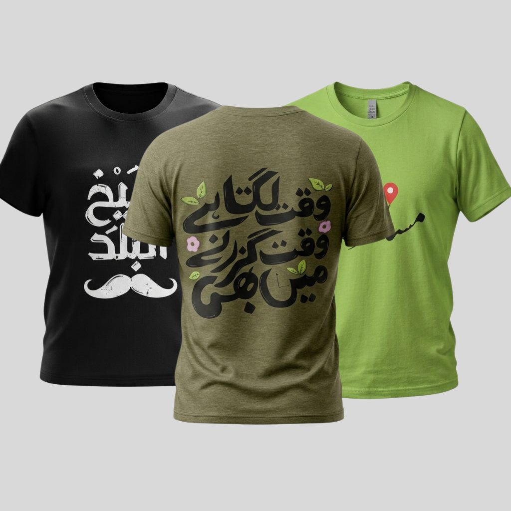 Three short-sleeve crew-neck t-shirts shown against a light gray background: a black shirt on the left with white Arabic calligraphy, a heather gray shirt in the center with peach Arabic text across the chest, and an olive green shirt on the right with white Arabic text and a white mustache graphic.