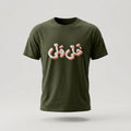 An olive green short-sleeve t-shirt with stylized Arabic calligraphy printed across the chest in white with a pink shadow, shown against a light gray background.