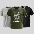 Three short-sleeve graphic T-shirts shown on a light gray background: a heather gray shirt on the left with a peach Arabic calligraphy print, an olive green shirt in the center with large white Arabic calligraphy and a white mustache graphic, and a black shirt on the right with a white Arabic calligraphy print.